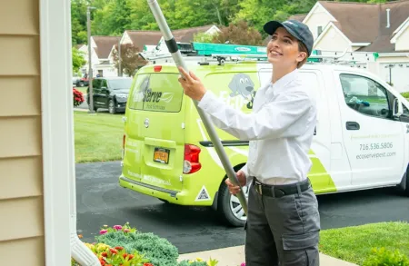 Eco Serve Technician sweeping exterior of home