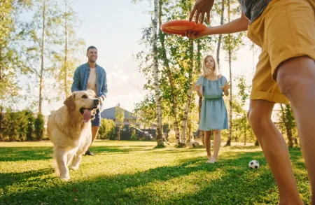 family playing with dog in back yard