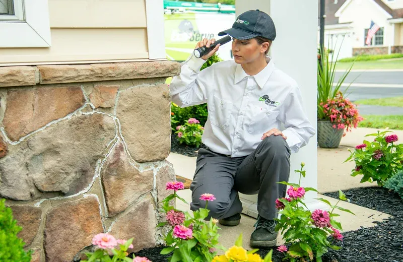 Eco Serve Technician inspecting exterior of home
